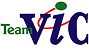 Logo with the word "Team" in green text on the left, and the word "VIC" in large, dark blue serif font. A red curved line connects the "m" of "Team" to the "V" of "VIC", and a green circle sits above the "V".